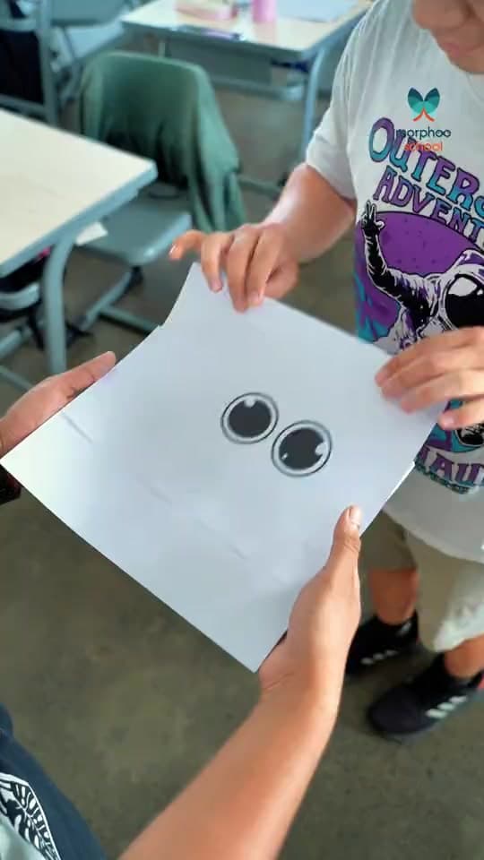 Pupils' hands hold up drawings, each made around the same two sticker eyes: a pink bus, a creature, a blue shirt, a rainbow landscape and more, with the lines "Creativity is the courage to see things differently" and "Because imagination matters more than perfection", ending on the Morphoo School logo