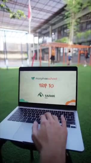 A Morphoo School trip to a safari park: pupils feed koi, ride a bus to see the animals, watch a lion, listen to their teacher Ms. Selvi among the trees and say what they learned, ending on the Morphoo School logo