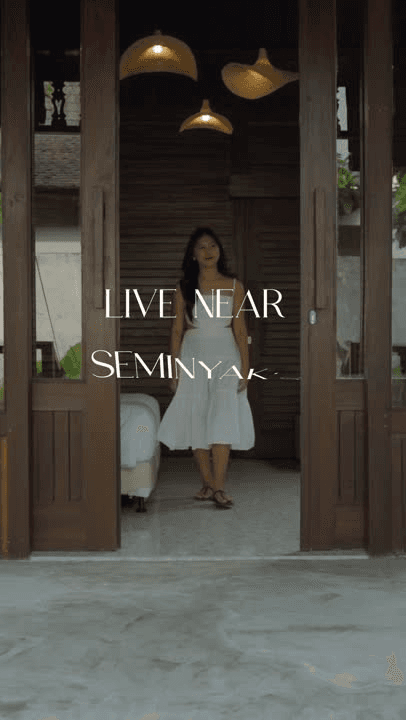 A woman at a wooden doorway, with the line Live near Seminyak
